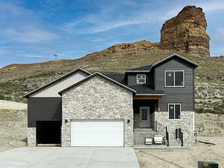 627 Memory Lane featuring tan and coffee siding, brown shingles, sleek black hardware and finishes, jasmine white quartz countertops, and white cabinetry.